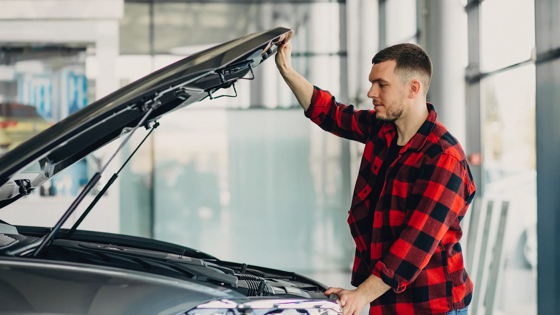 photo of a man inspecting a used car under the hood