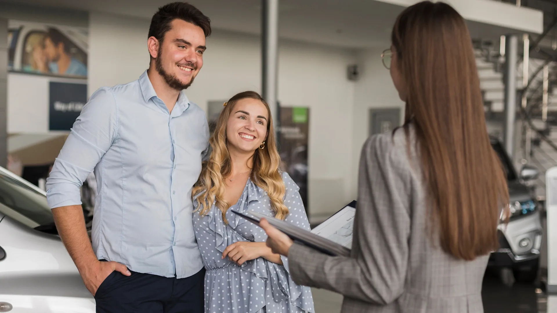 photo of customers talking with a salesperson at a car dealership