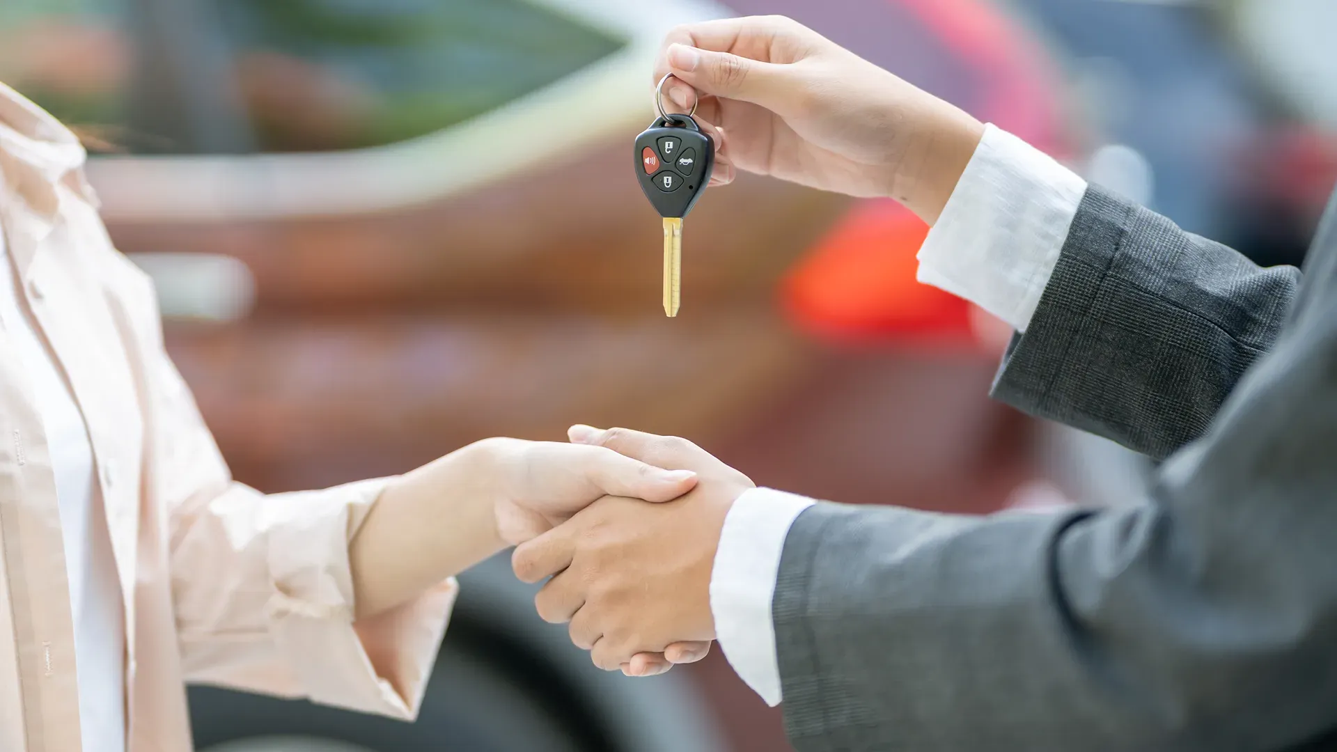 Handing over the car keys after a successful deal.