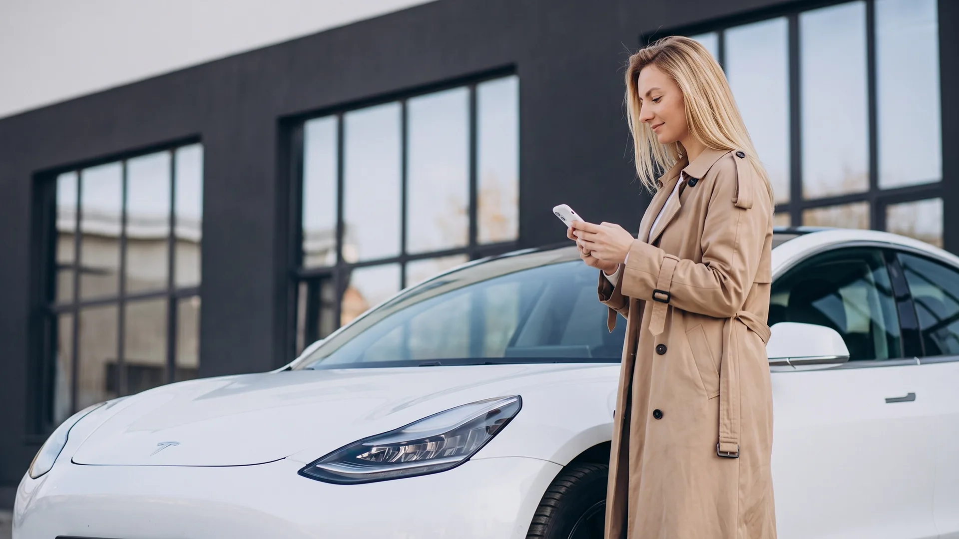 The woman is standing next to her tesla