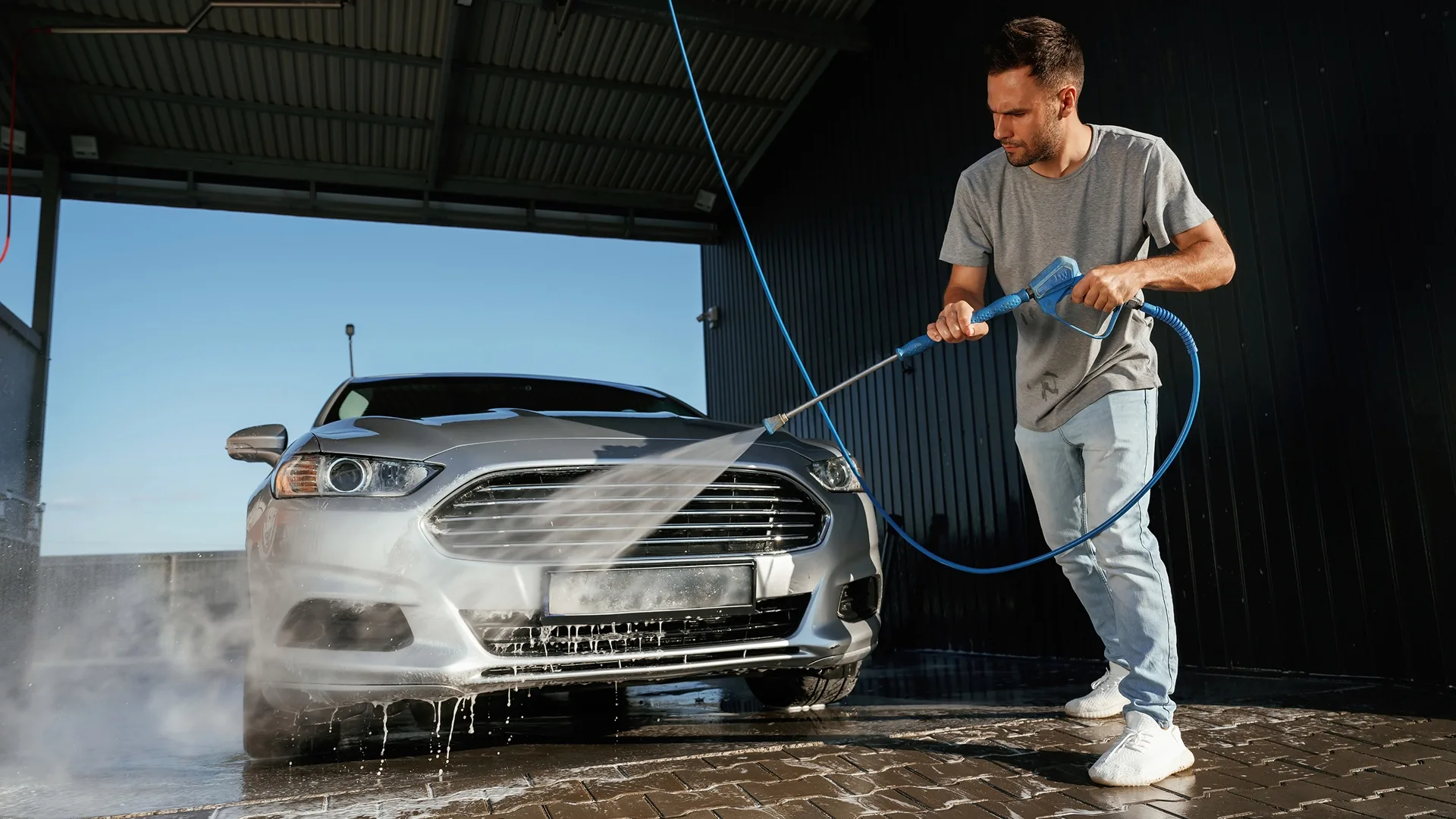 A seller washing a car before taking photos for an online vehicle listing