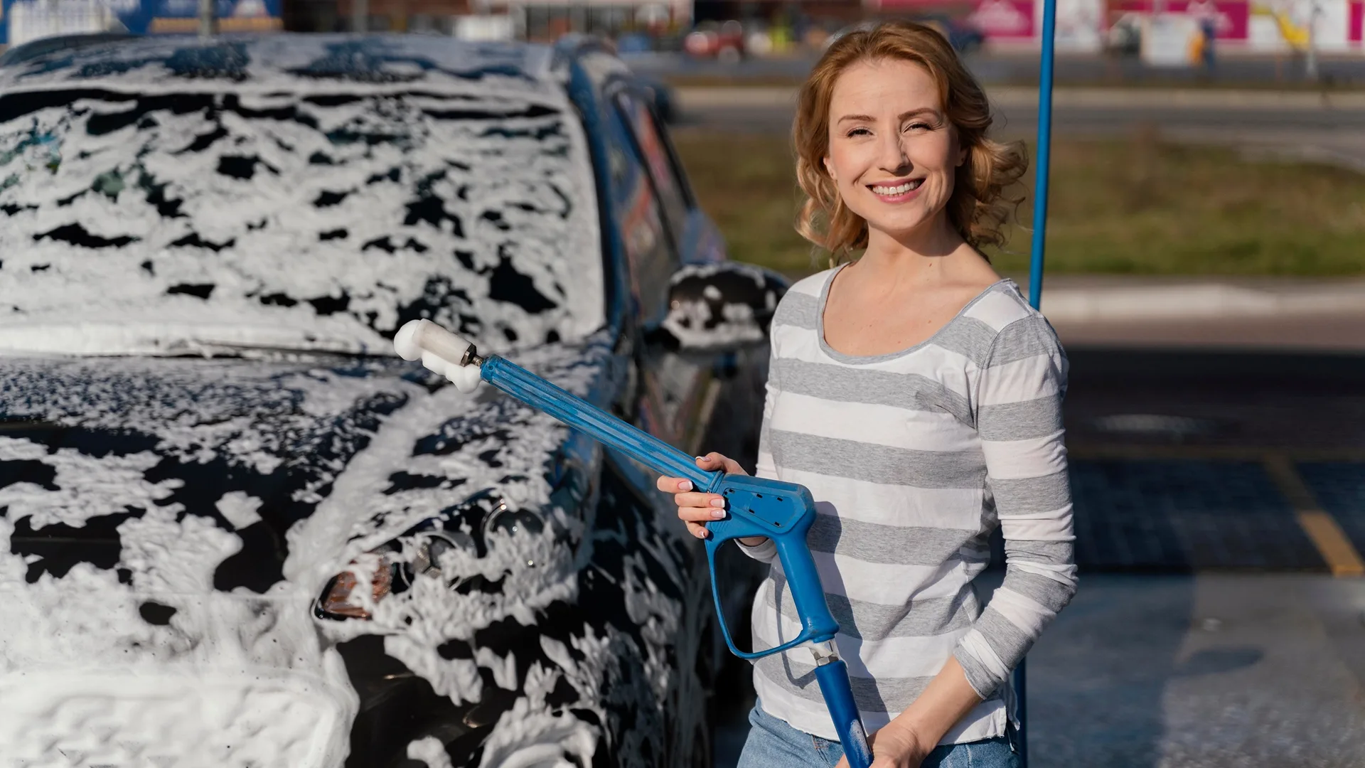 photo of a woman washing a car before selling it