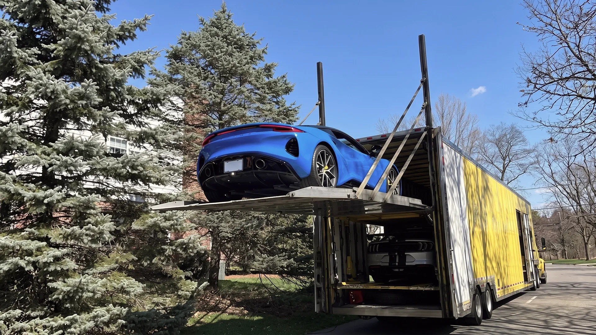 Luxury car being loaded into an enclosed auto carrier