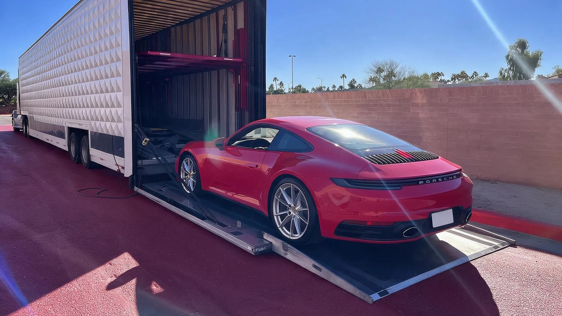 Vehicle being loaded into an enclosed auto transport carrier