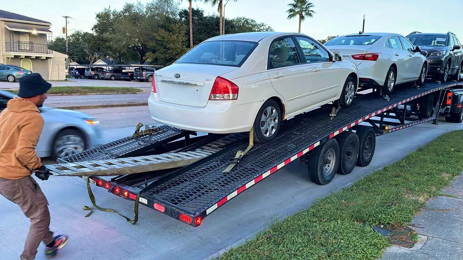 photo of cars being loaded onto an open auto transport carrier