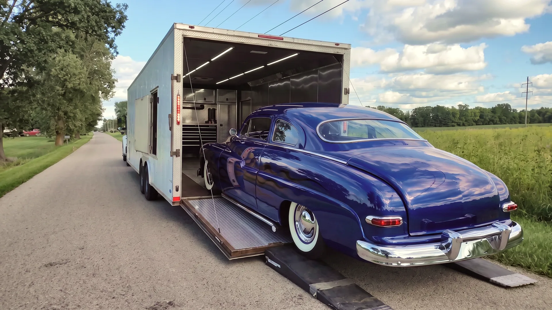 Modified car being loaded into an enclosed auto transport trailer