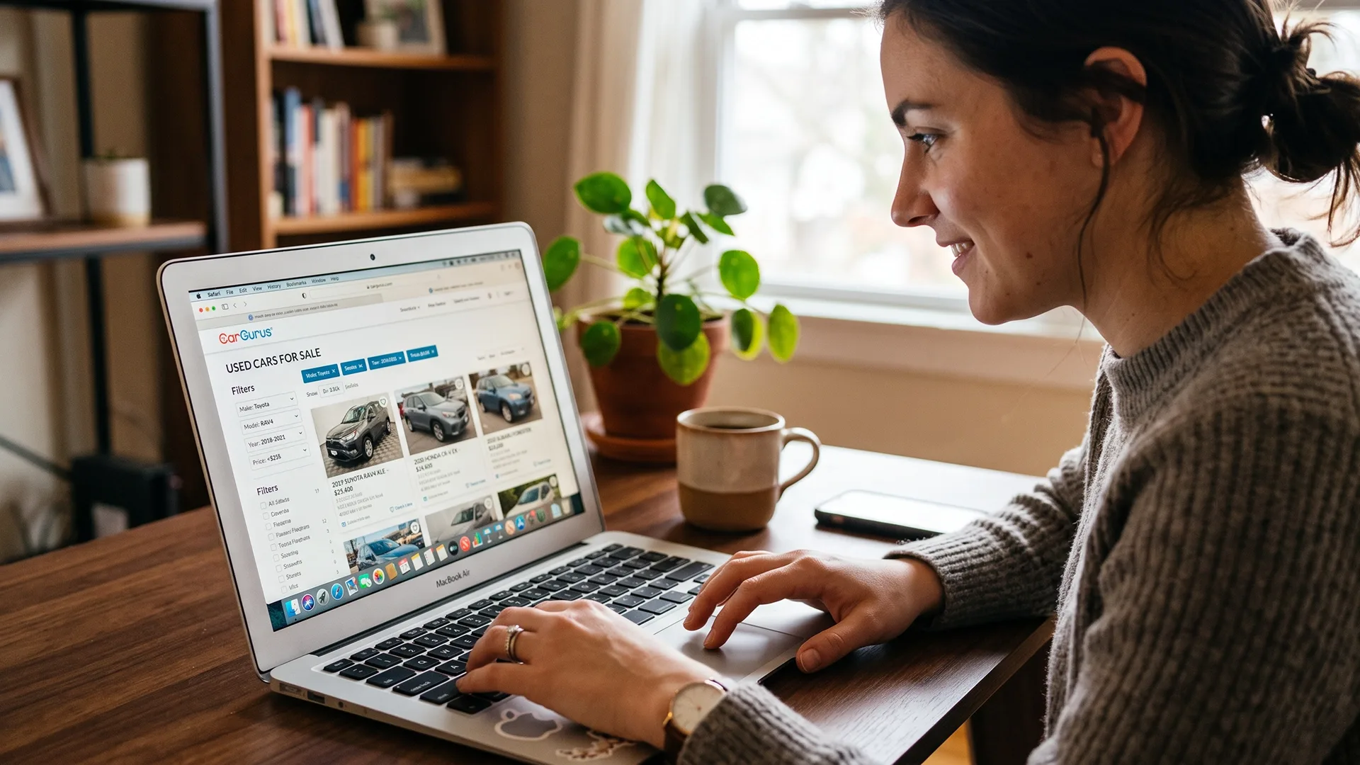 photo of woman browsing used cars online on laptop