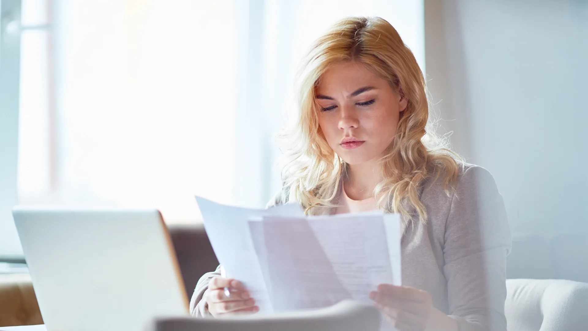 A woman is looking at and trying to make sense of her car insurance.