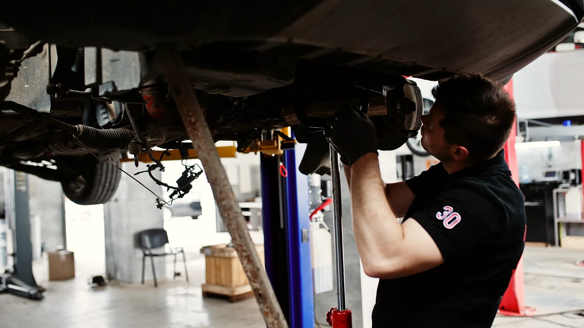 A man carries out a routine inspection of the car.