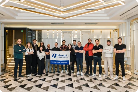 Nexus Auto Transport team members in the company office holding a branded sign
